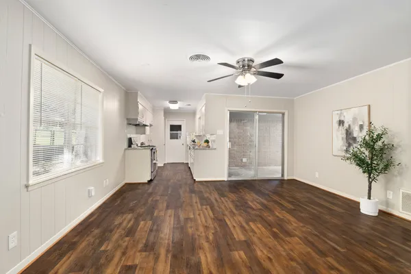 a view of a big room with wooden floor and a chandelier fan