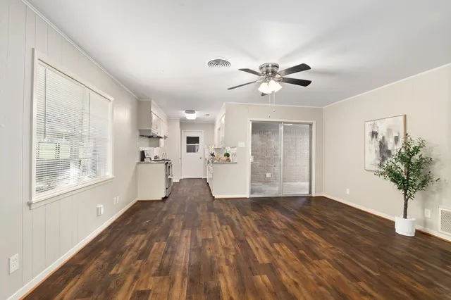a view of a big room with wooden floor and a chandelier fan