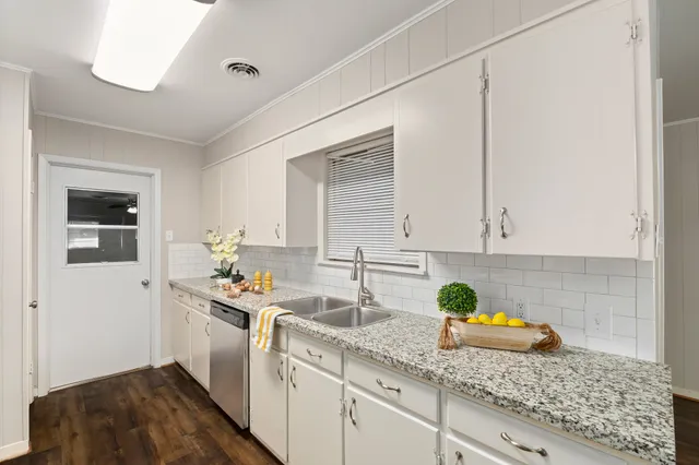 a kitchen with a sink a stove cabinets and a window