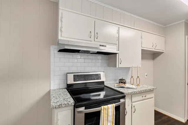 a kitchen with granite countertop cabinets stainless steel appliances and wooden floor