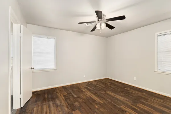a view of empty room with wooden floor