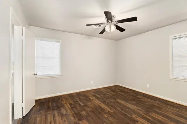 a view of empty room with wooden floor