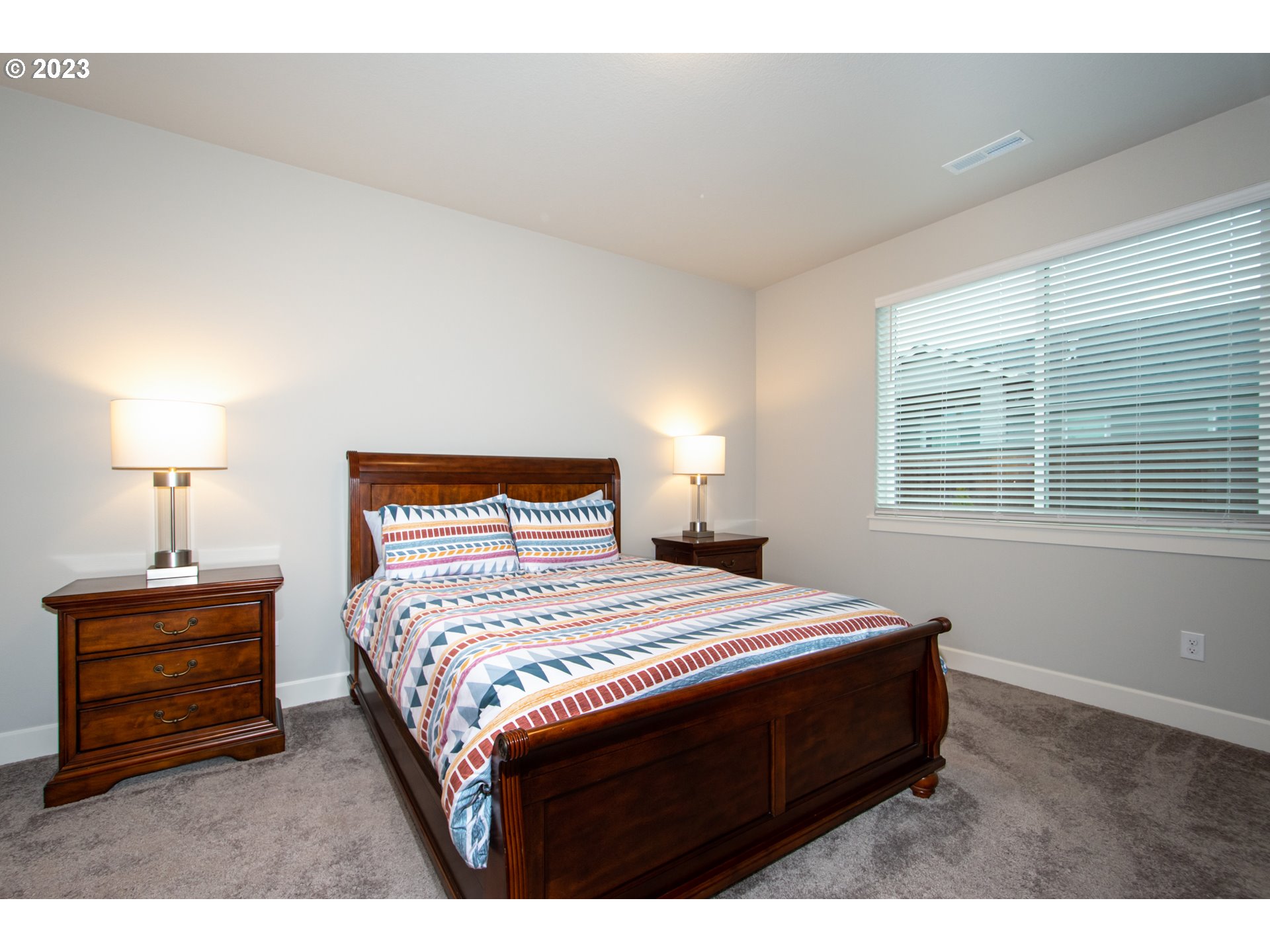 4916 South 17th Drive Ridgefield, WA 98642 - Photo 12 of 26 a bedroom with a bed a lamp and a window