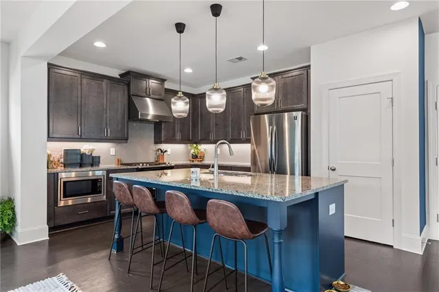 a kitchen with stainless steel appliances granite countertop wooden cabinets a sink and a stove