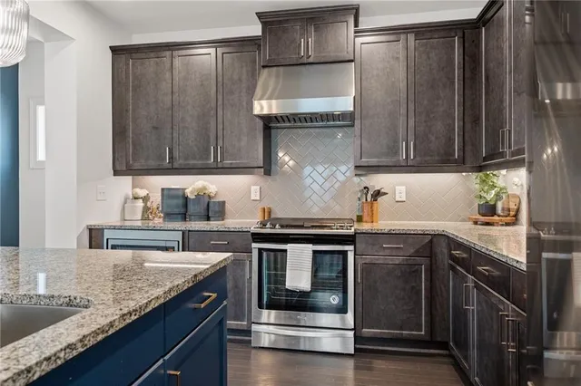 a kitchen with granite countertop a sink stove and refrigerator