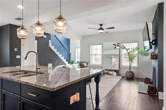 a kitchen with stainless steel appliances granite countertop a sink a stove and a wooden floors