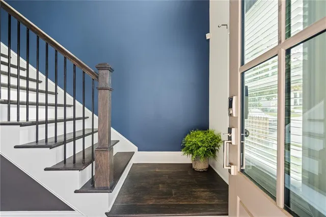 a view of a hallway with wooden floor and staircase