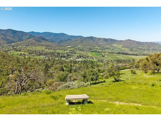 a view of a house with a big yard and large trees