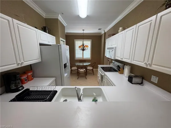 a view of a kitchen with kitchen island a counter top space a sink wooden floor and cabinets