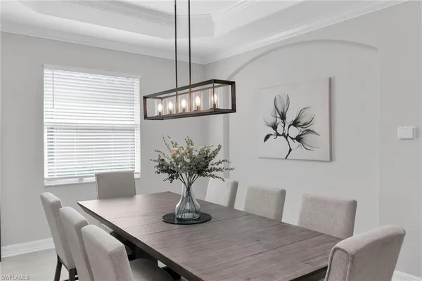 a living room with furniture a chandelier and a potted plant