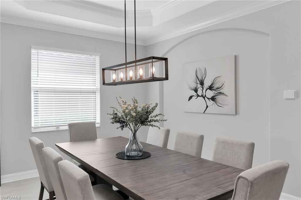 2926 Aviamar Circle Naples, FL 34114 - Photo 11 of 44 Dining room with ornamental molding, a raised ceiling, and light wood-type flooring