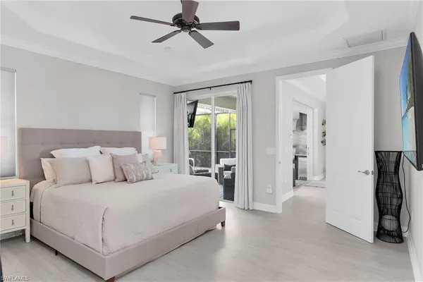a bedroom with a large bed and a flat tv screen on dresser