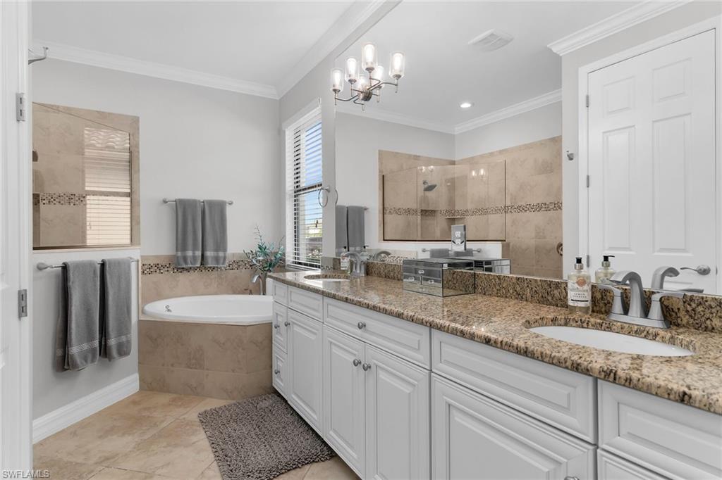 2926 Aviamar Circle Naples, FL 34114 - Photo 16 of 44 Bathroom featuring walk in shower, double vanity, ornamental molding, a bath, and suspended lighting
