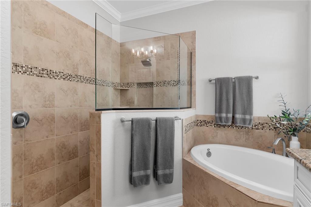 2926 Aviamar Circle Naples, FL 34114 - Photo 17 of 44 Bathroom with crown molding, a bath, vanity, and a walk in shower