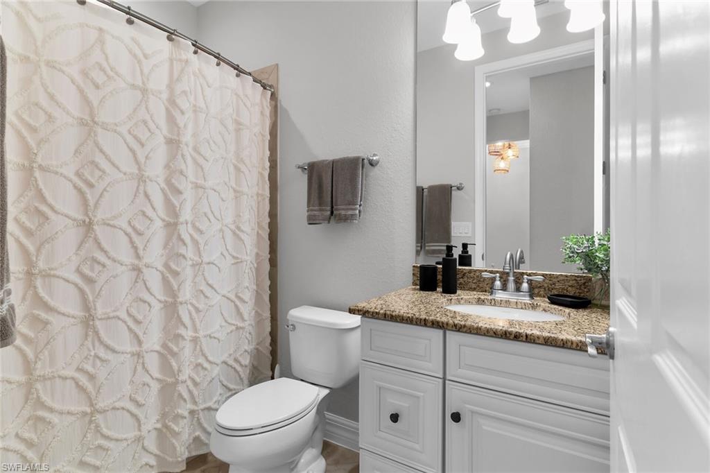 2926 Aviamar Circle Naples, FL 34114 - Photo 19 of 44 Full bathroom with vanity, curtained shower, and a textured wall