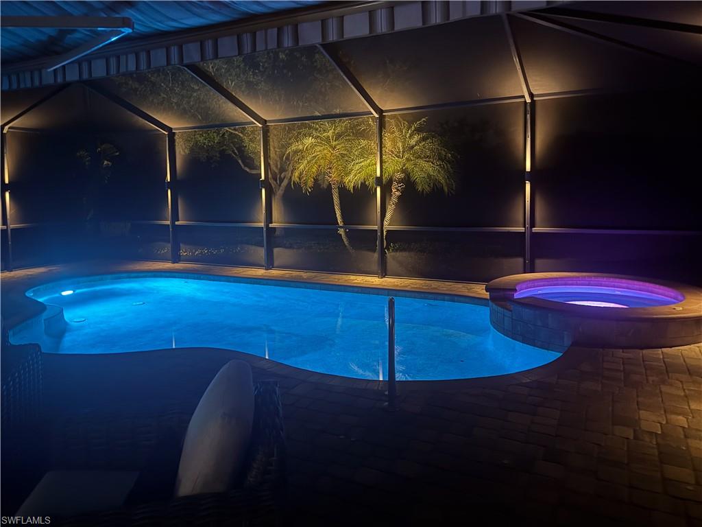2926 Aviamar Circle Naples, FL 34114 - Photo 26 of 44 Pool at night with a pool with connected hot tub