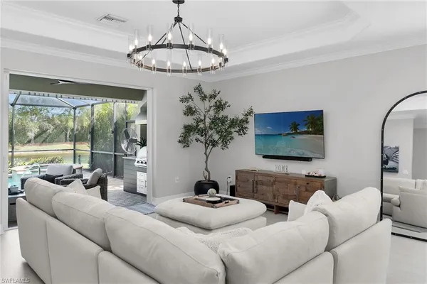 a living room with furniture a chandelier and a flat screen tv