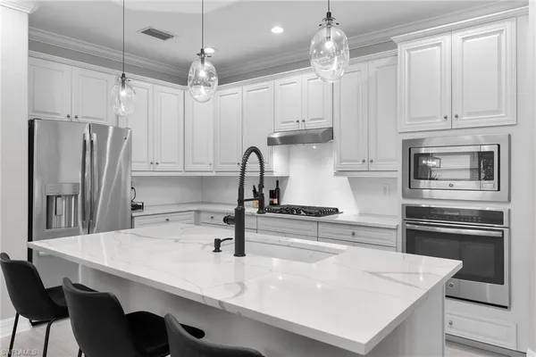 a kitchen with kitchen island a sink stainless steel appliances and cabinets