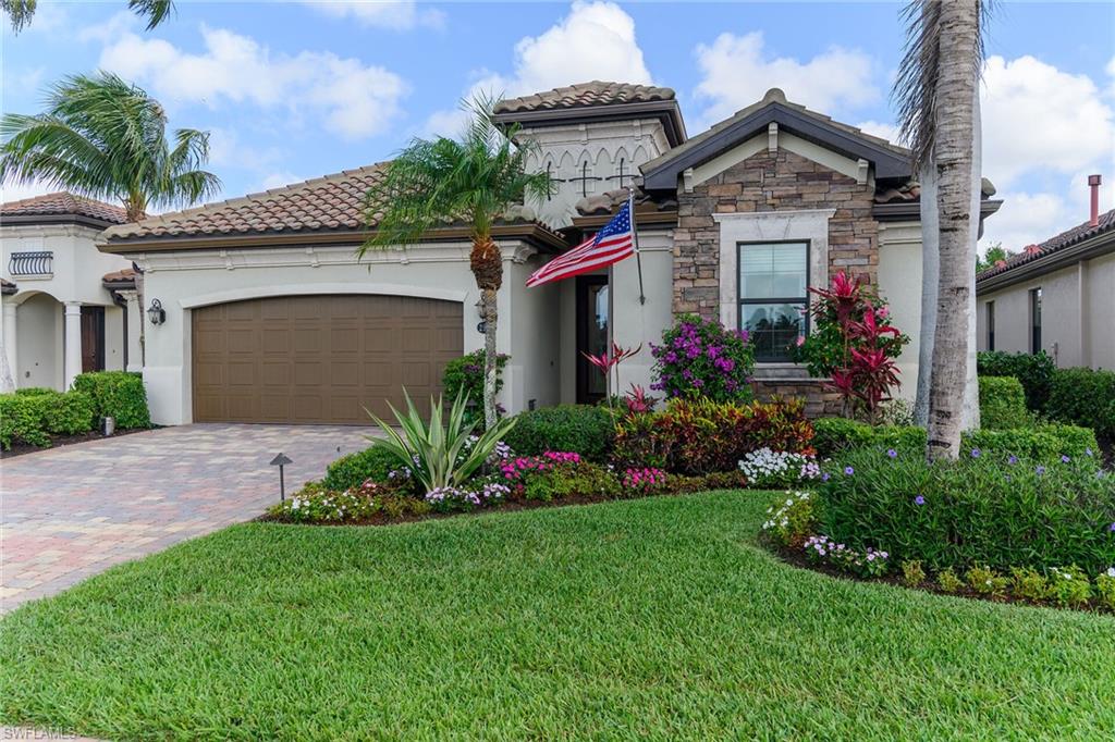 2926 Aviamar Circle Naples, FL 34114 - Photo 7 of 44 Mediterranean / spanish-style house featuring a garage, stone siding, decorative driveway, stucco siding, and a front lawn