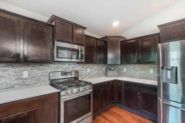 a kitchen with stainless steel appliances wooden cabinets and stove