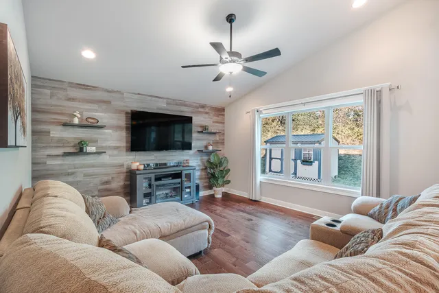 a living room with furniture ceiling fan and a flat screen tv