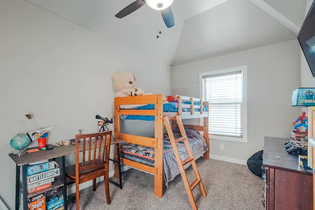a bedroom with furniture a rug toys and a window