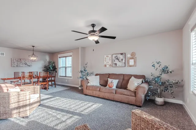 a living room with furniture kitchen view and a chandelier