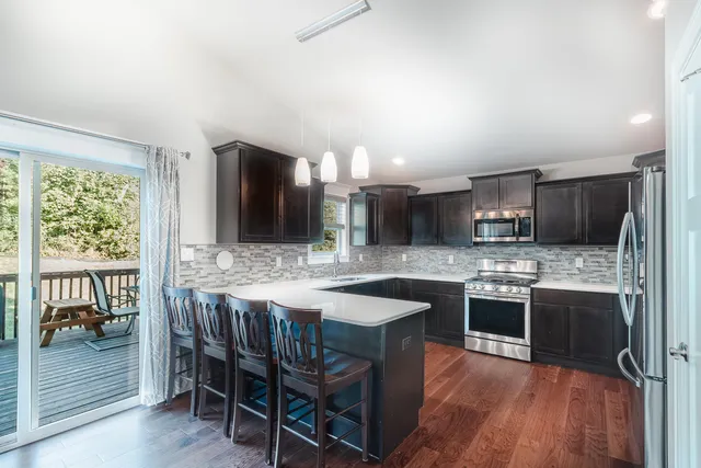 a kitchen with stainless steel appliances granite countertop a stove and a wooden floors