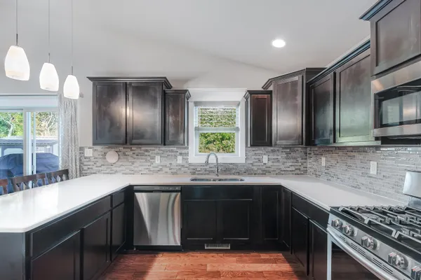 a kitchen with stainless steel appliances granite countertop a sink and stove