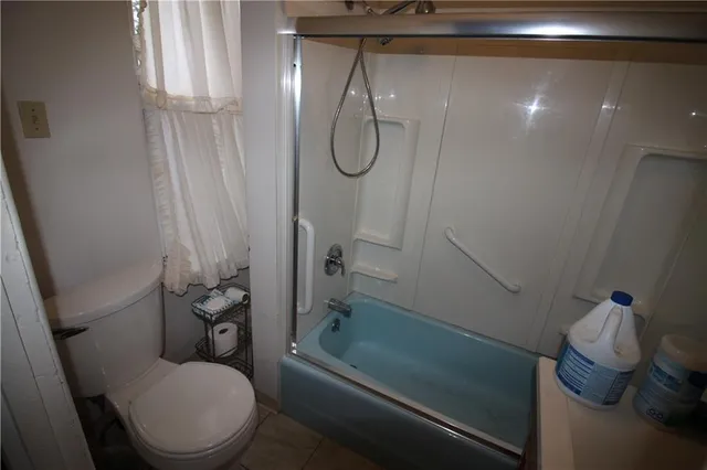 a bathroom with a granite countertop toilet and a shower