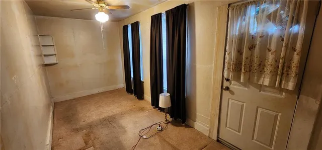 a view of a hallway and a chandelier fan