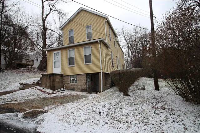 a view of a house with a yard covered in snow