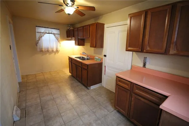 a kitchen with stainless steel appliances a sink cabinets and wooden floor