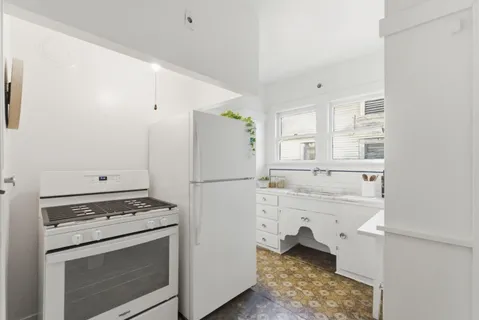 a kitchen with white cabinets and white appliances
