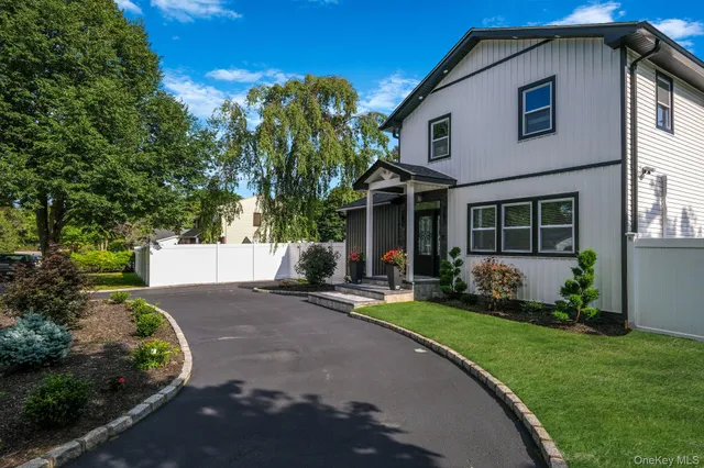 a front view of a house with a yard and garden