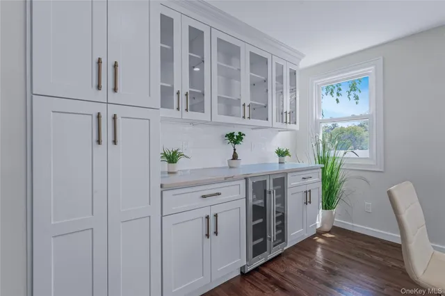 a kitchen with stainless steel appliances white cabinets and wooden floor