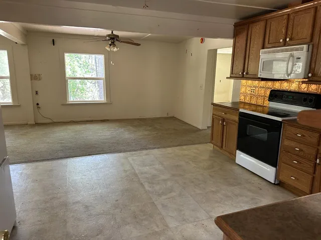 a kitchen with stainless steel appliances granite countertop a stove a sink and a microwave