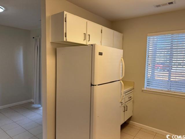 425 Myrtle Greens Drive, Unit B Conway, SC 29526 - Photo 15 of 18 Kitchen with freestanding refrigerator, white cabinets, light tile patterned flooring, and light countertops