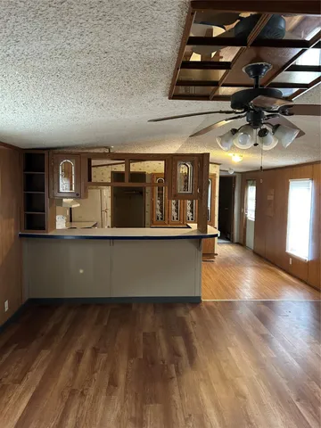 a view of kitchen with stainless steel appliances granite countertop a dishwasher a stove top oven a dining table and chairs with wooden floor