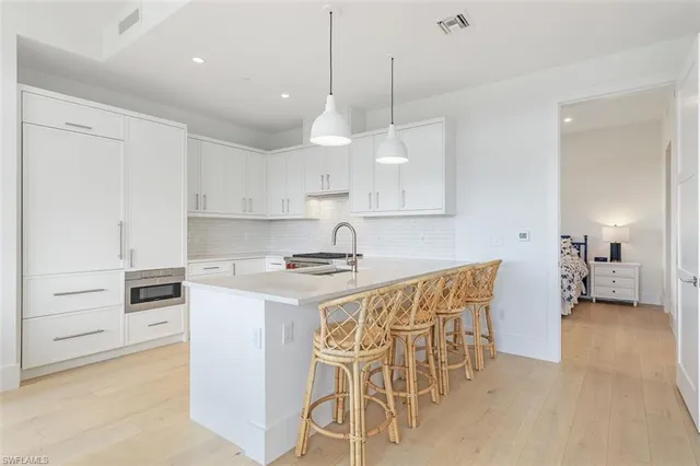 a kitchen with stainless steel appliances a stove a sink a counter top space and cabinets