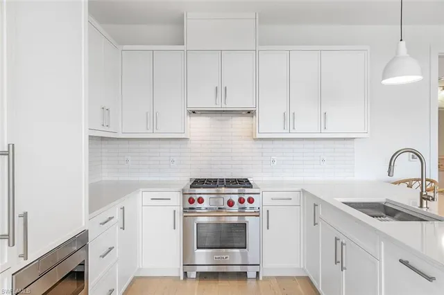 a kitchen with white cabinets and white appliances