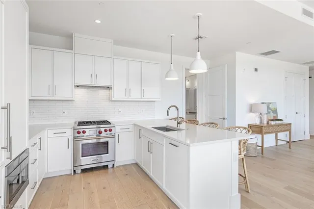 a kitchen that has a sink a stove and a wooden floor