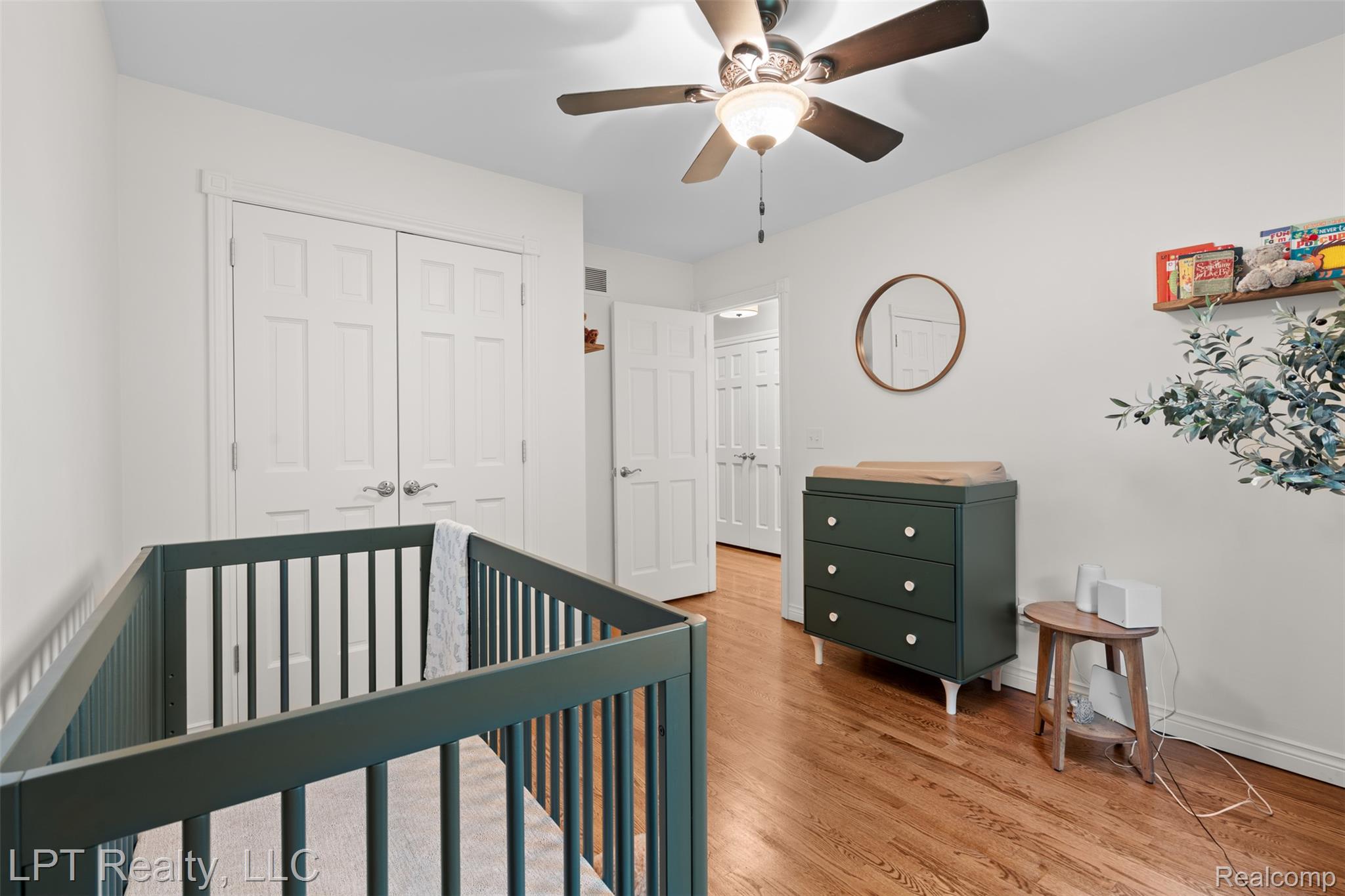 2588 East Jones Road Howell, MI 48855 - Photo 16 of 40 Bedroom featuring a closet, a crib, wood finished floors, and a ceiling fan