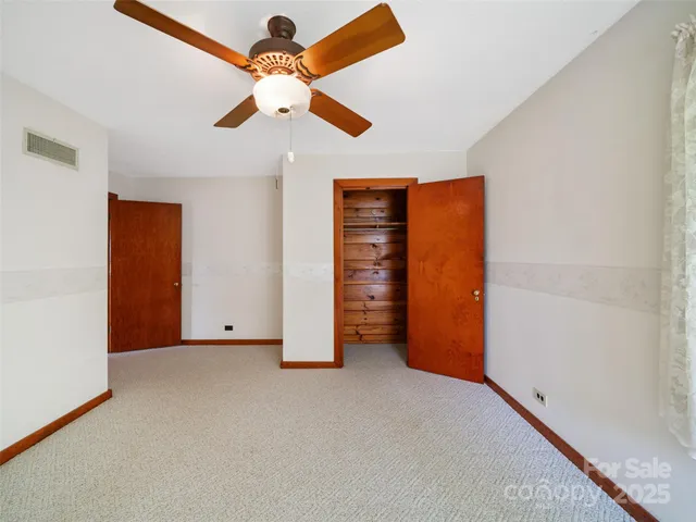 an empty room with closet and fan