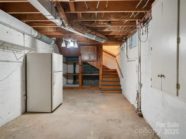 a view of a room with stairs and a refrigerator
