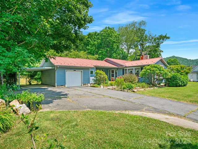 a front view of a house with yard and green space