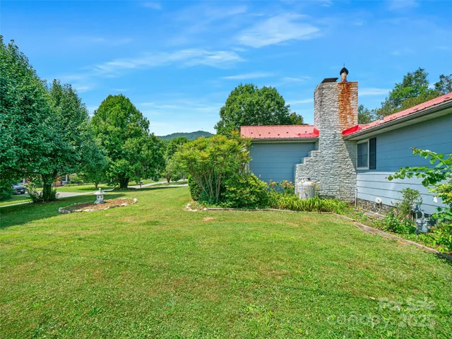 a front view of a house with a yard and trees