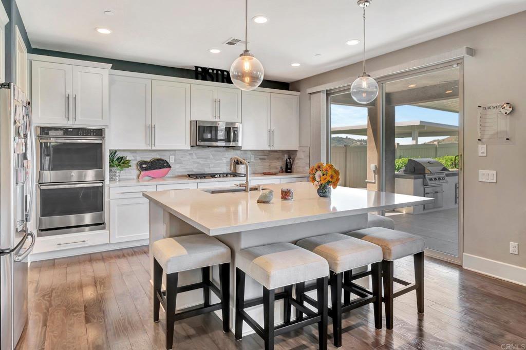35822 Blue Breton Drive Fallbrook, CA 92028 - Photo 12 of 47 a kitchen with a dining table chairs and refrigerator