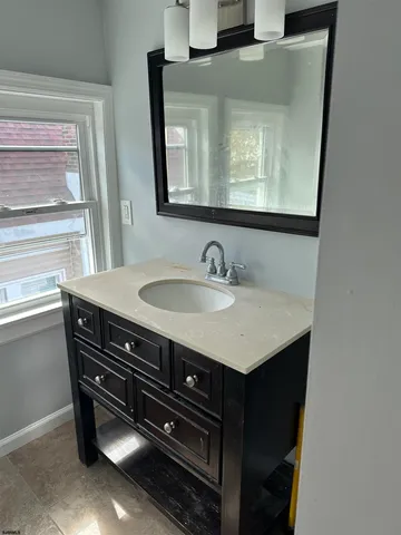 a bathroom with a sink toilet and window