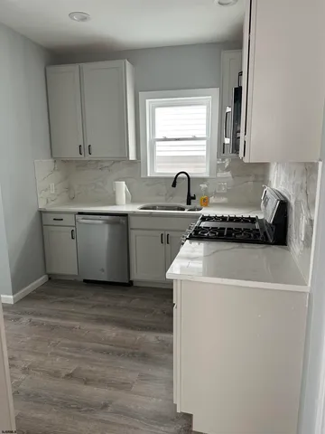 a kitchen that has a sink and a stove in it